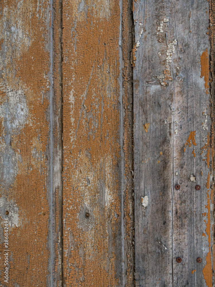 An old wooden wall texture with peeling faded brown paint An old wooden wall texture with peeling faded brown paint