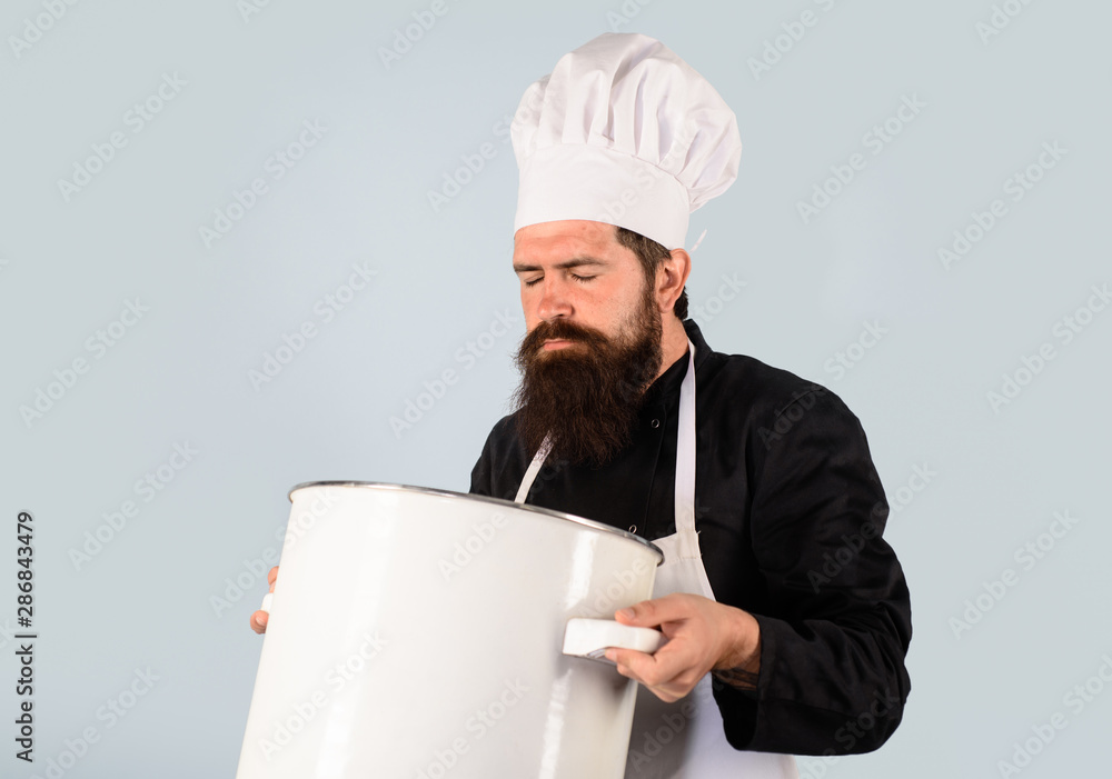 Saucepan, casserole. Cook man in apron holds saucepan in kitchen. Cooking pot. Cookware, dinnerware, kitchenware. Male chef cook holds big pot. Cooking, culinary. Food, profession and people concept. Saucepan, casserole. Cook man in apron holds saucepan in kitchen. Cooking pot. Cookware, dinnerware, kitchenware. Male chef cook holds big pot. Cooking, culinary. Food, profession and people concept.