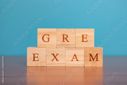 Concept of GRE Exam in wooden block letters on table.
