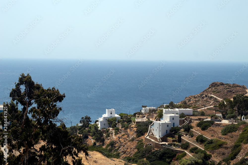 Greece, Ios, Cyclades. View to sea over Mylopotos bay. Clear blue sky, the heat of August. Contrast between the deep blue hues of the sea and sky.