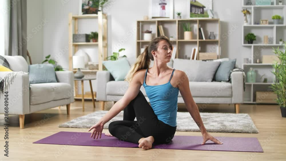 Pretty yoga woman stretches legs, bends and stretches at home Pretty yoga woman stretches legs, bends and stretches at home