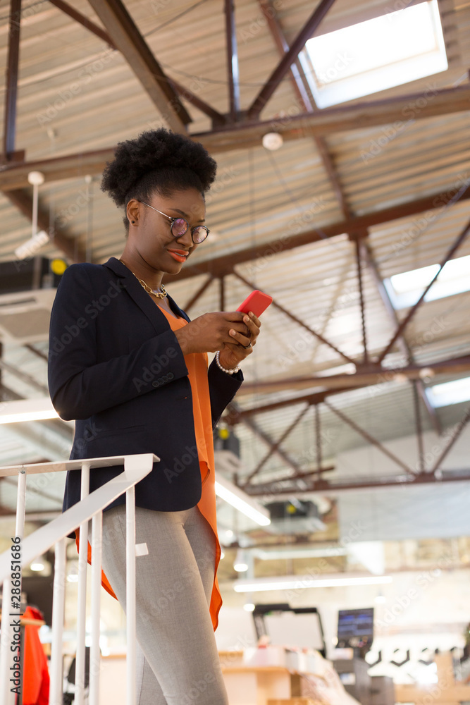 Fototapeta premium Designer wearing glasses reading message on phone
