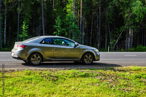 Coupe car on side of a country highway in autumn