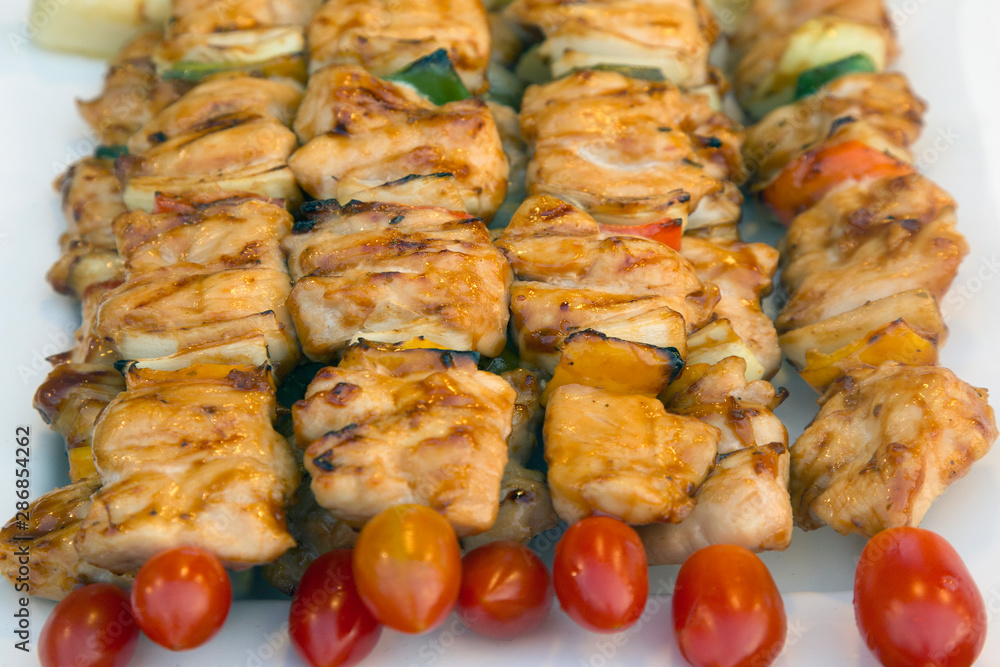 Assorted meat from chicken and pork and various vegetables on barbecue grill 