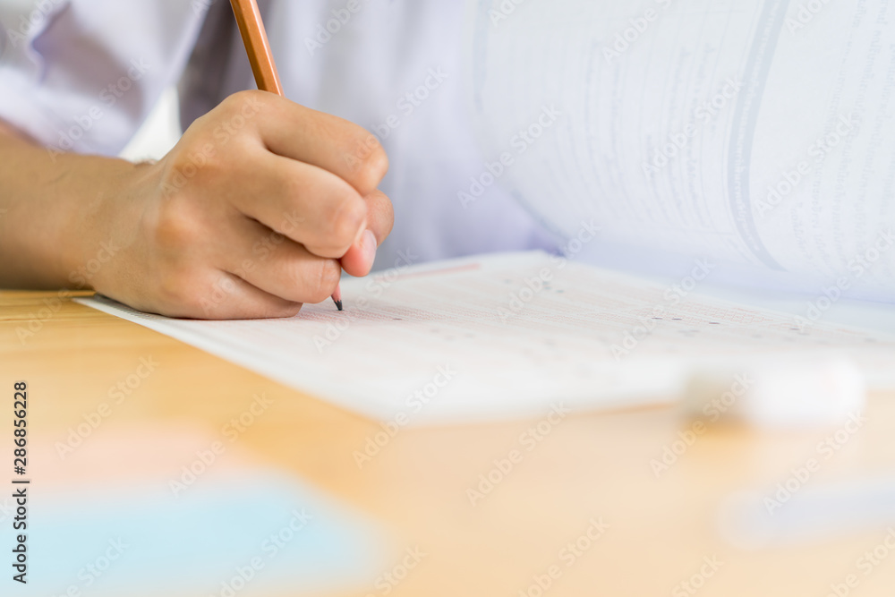 hand student testing in exercise taking fill in exam carbon paper answer sheet with pencil at school or university in test room, document exams at campus classroom, education or back to school concept hand student testing in exercise taking fill in exam carbon paper answer sheet with pencil at school or university in test room, document exams at campus classroom, education or back to school concept