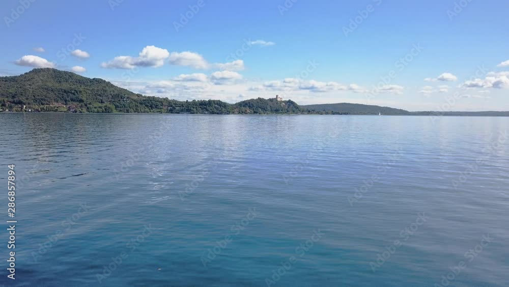 Sail boat on the lake aerial shot. Camera flying backwards close to the boat - beautiful panorama in the background Sail boat on the lake aerial shot. Camera flying backwards close to the boat - beautiful panorama in the background