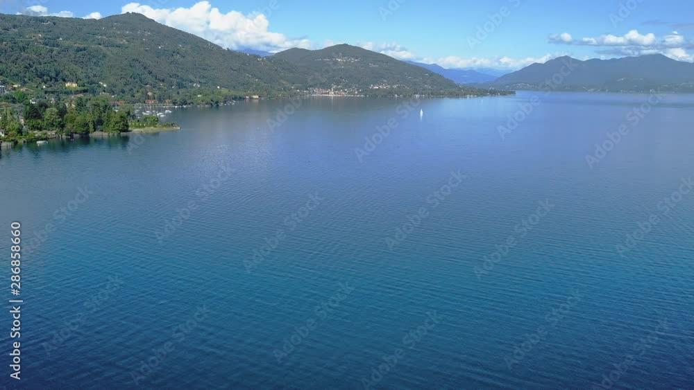 Lake Maggiore aerial shot iconic view. Camera flying over the blue water Lake Maggiore aerial shot iconic view. Camera flying over the blue water