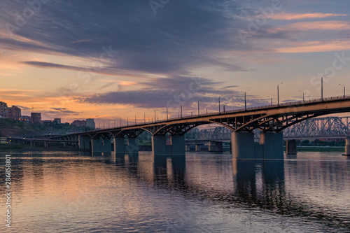 Bridge over the Yenisei river, evening sunset. Krasnoyarsk, Russia. panorama of the evening city