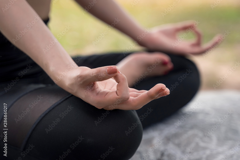 Young beautiful woman practices yoga and meditates outdoor at the mountain. Female doing yoga and meditate to relax and release stress.