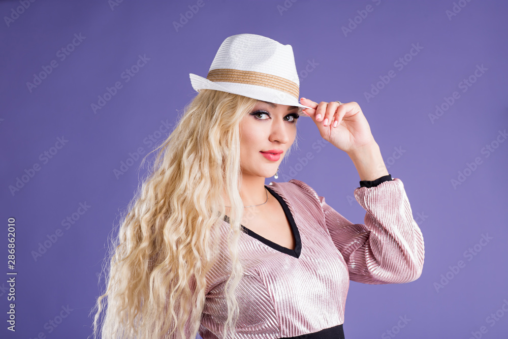 Beautiful young woman in sun hat on purple background Beautiful young woman in sun hat on purple background