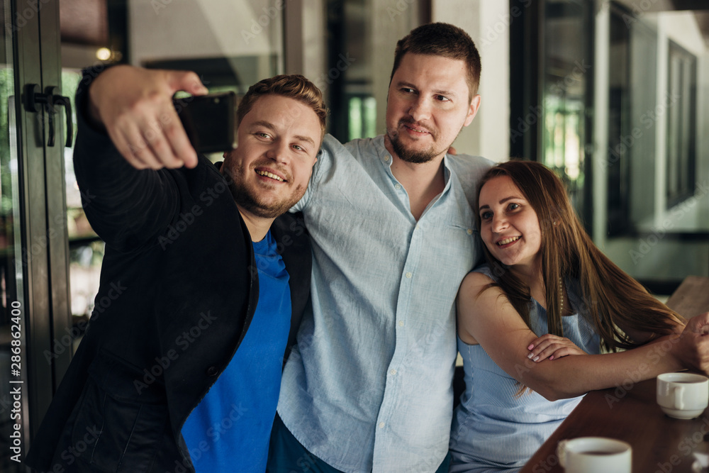 Fototapeta premium Adult friends taking selfie in dining room