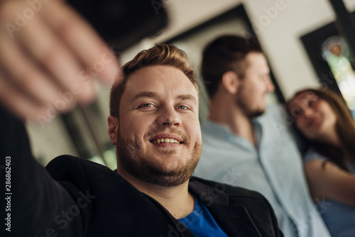 Man taking selfie with friends indoors