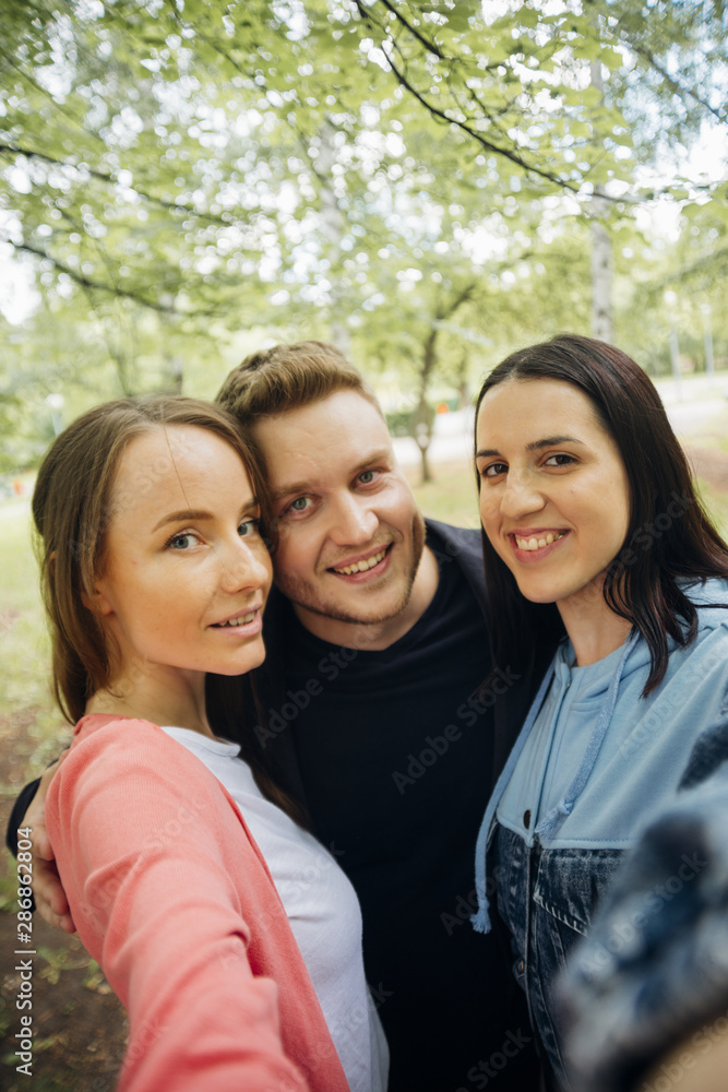 Cheerful friends taking selfie in park Cheerful friends taking selfie in park