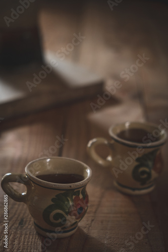 two antique cups of decorated coffee