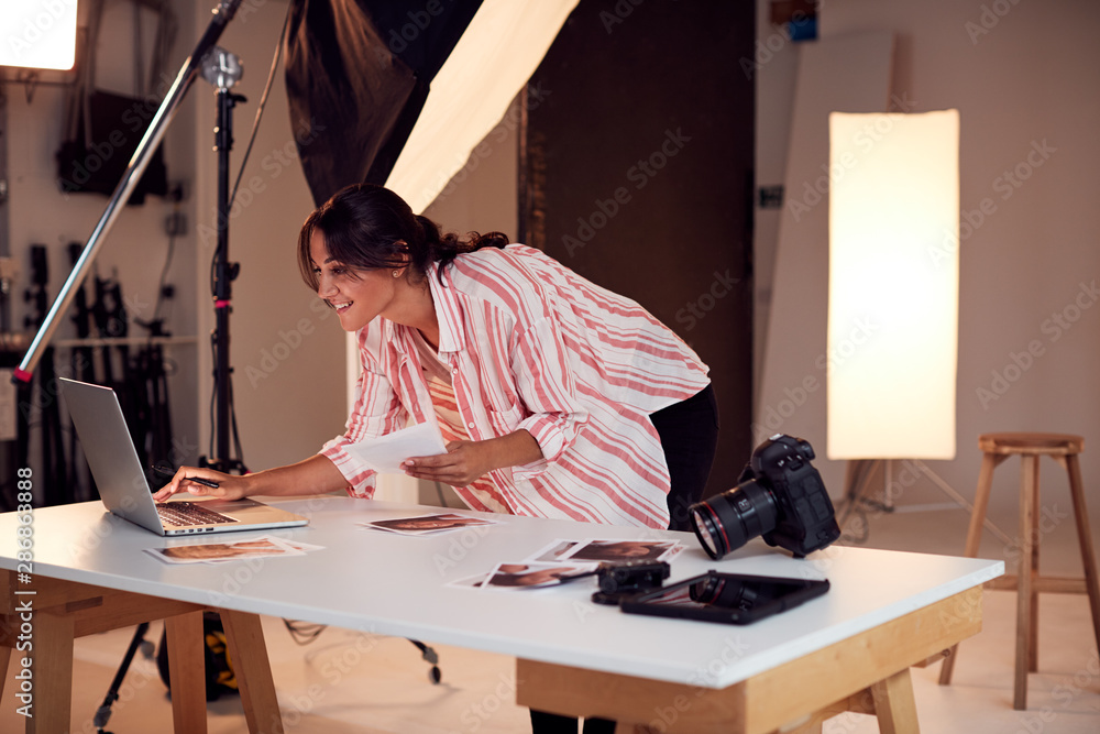 Female Photographer Editing Images From Photo Shoot In Studio Female Photographer Editing Images From Photo Shoot In Studio