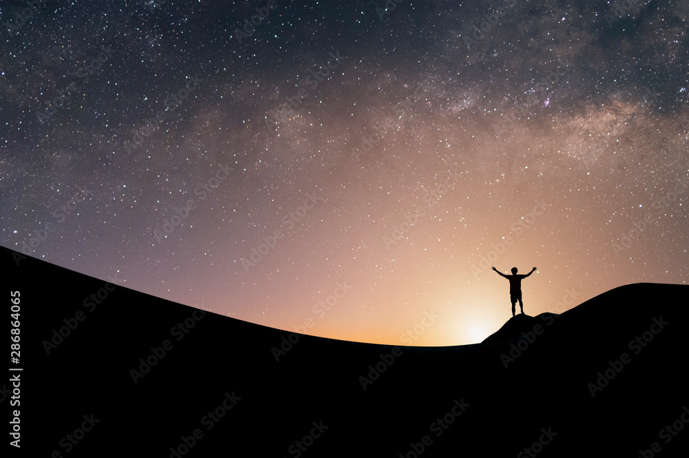 Fototapeta premium Silhouette of traveler open arm and watching the star and milky way on the top of the mountain