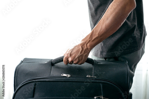 Man hand holding black luggage