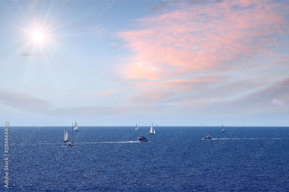 Sailboats on sea with sunny sky