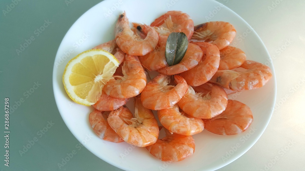 Kitchen and food, cooked shrimp, shrimp in a plate. Boiled shrimp with lemon. roasted prawns on white plate, top view. Kitchen and food, cooked shrimp, shrimp in a plate. Boiled shrimp with lemon. roasted prawns on white plate, top view.