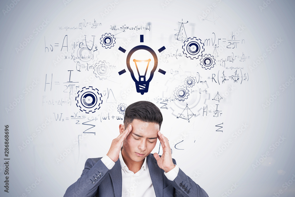 Stressed Asian man thinking about formulas Stressed Asian man thinking about formulas