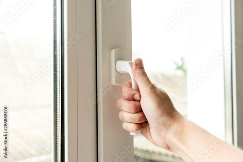 Hand open window at home.