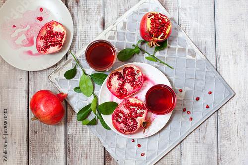 Fototapeta Naklejka Na Ścianę i Meble -  Pomegranate juice with fresh pomegranate fruits on wooden table