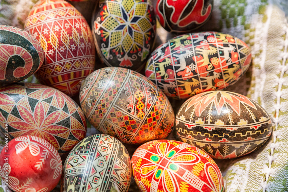 Easter wooden eggs into national old Russian patterns on a plate with a kitchen towel. Flat lay composition of painted Easter eggs Easter wooden eggs into national old Russian patterns on a plate with a kitchen towel. Flat lay composition of painted Easter eggs