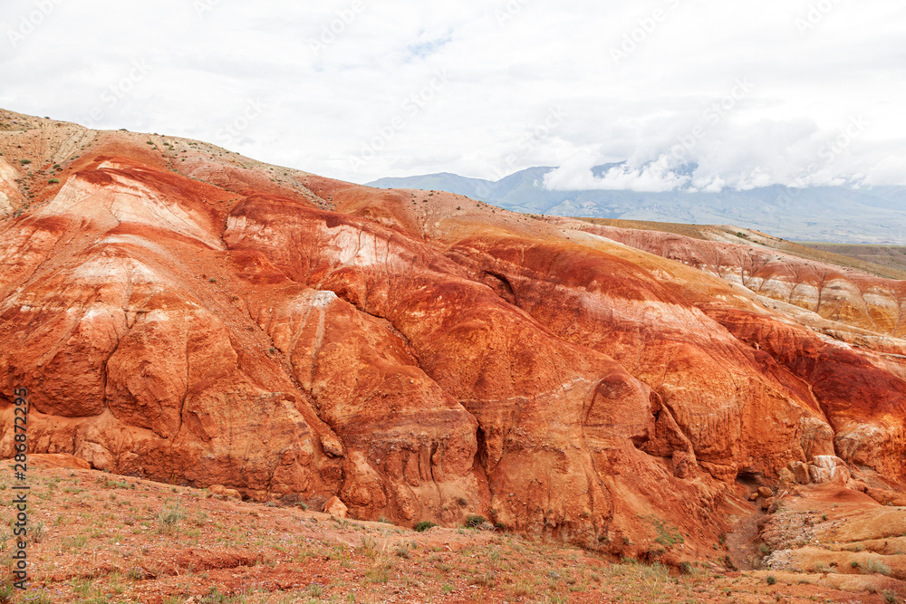 A stunning panorama of a mountain chain of peaks, a canyon with red clay, top view. Mars fields in Altai, Russia. fantastic clay castles in the sandy desert of the red canyon