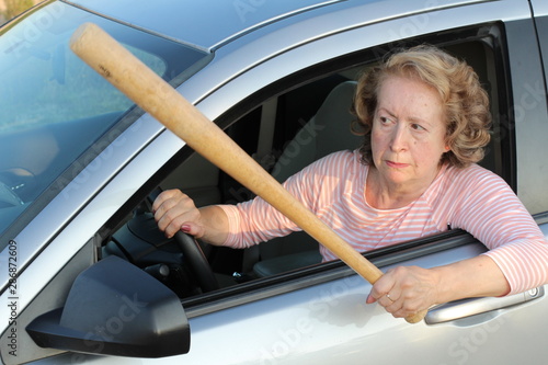 Angry mature female driver holding baseball bat  photo