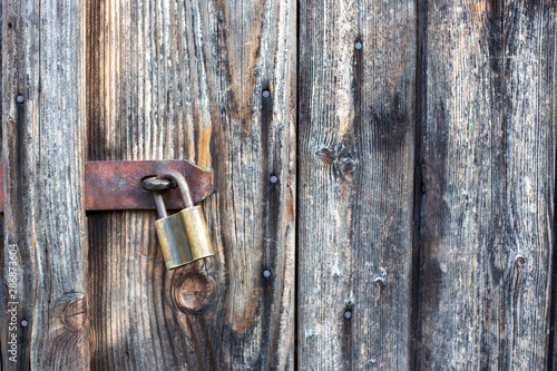 Brown wooden background texture with padlock. Vertical planks, bars
