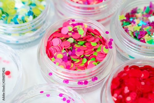 Colorful bright neon decor elements. For makeup, nail design, manicure and decoration. Confetti, sequins in jars
