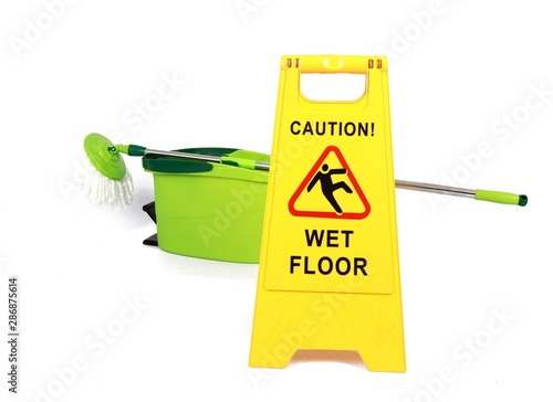 Cuadro en lienzo Yellow Caution slippery wet floor sign with mop and bucket in the background - S