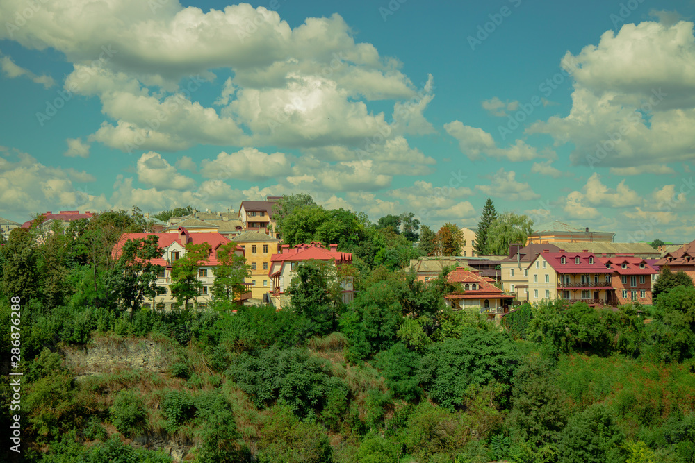 ecology green city colorful bright urban landmark picture with small houses in park outdoor trees natural environment on blue sky and white clouds background in Ukraine Eastern Europe