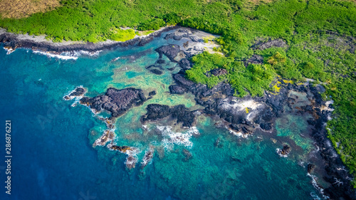Aerial view of turquoise water and rugged coastline over Keauhou Point Hawaii