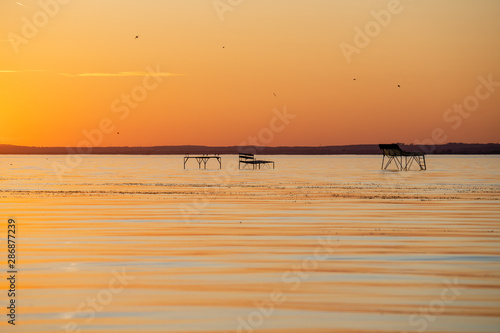 strong sunset at lake balaton with fishing spots fonyód district hungary summer vacation travel relax