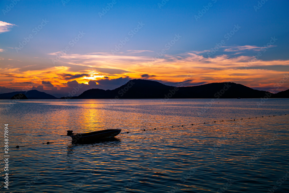 Small fishing boat in the sea sunset scenery, Beautiful Landscape and light of nature in evening with beautiful colors Clouds and sky