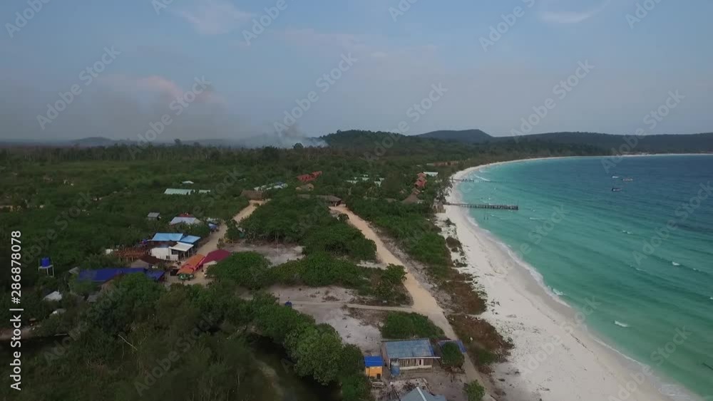 Aerial shot of a White Sandy tropical Beach and turquoise waters with resort buildings on Koh Rong Island Cambodia. Famous for its sandy coves and coral reefs Koh Rong is popular with tourists Aerial shot of a White Sandy tropical Beach and turquoise waters with resort buildings on Koh Rong Island Cambodia. Famous for its sandy coves and coral reefs Koh Rong is popular with tourists