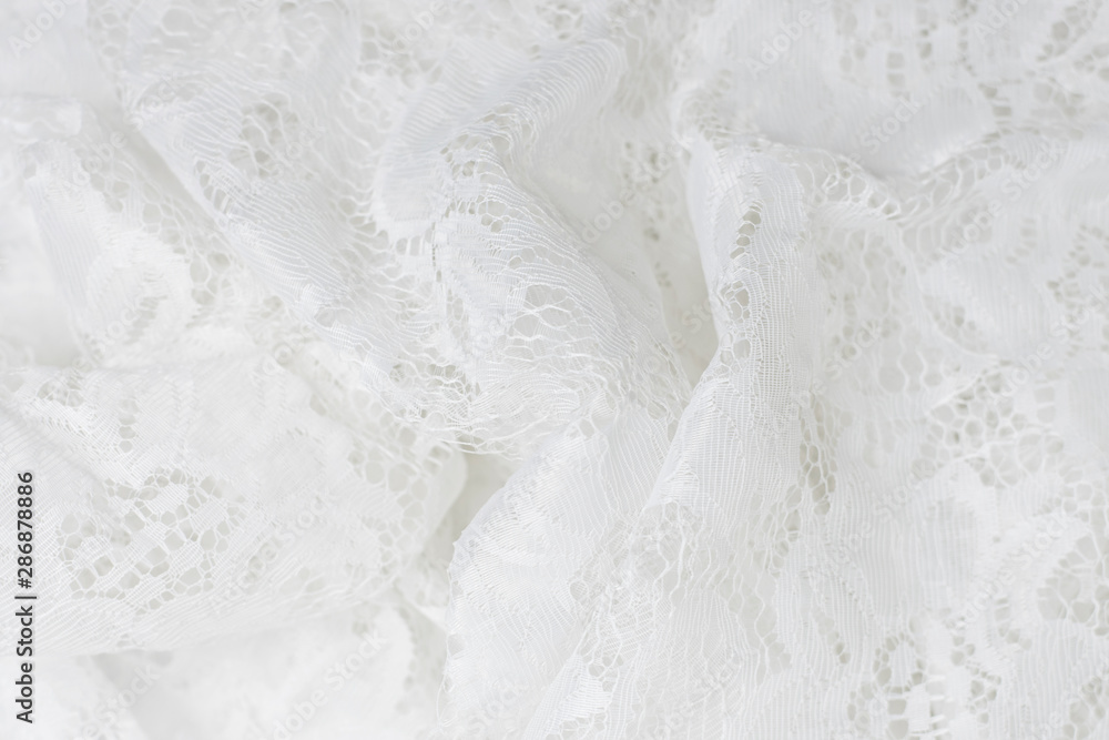 Obraz premium Wrinkled lace fabric cute white color, fragment closeup.