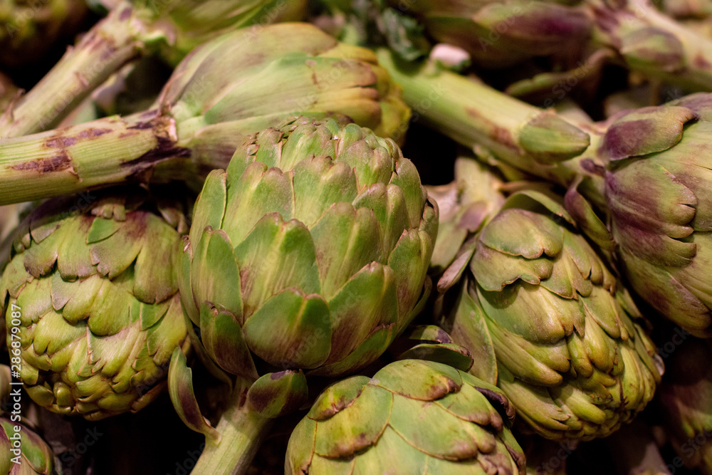 Fototapeta premium Fresh artichoke piled on the market. Food backgroumd. Harvest