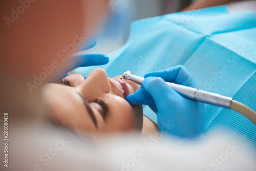 Happy woman treating teeth at a professional dentist