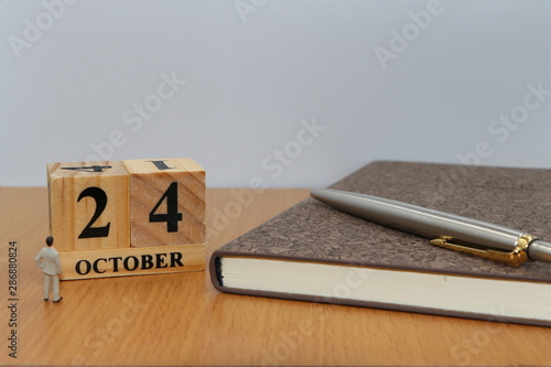 October  24, a calendar photo from the wood The table top consists of a book and pen that is ready to use. White background
