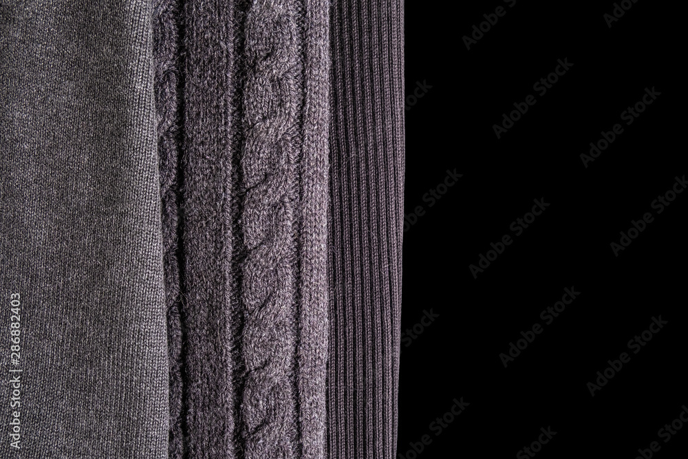 Three different patterns of wool knitting. top view to gray knitwear on black background Three different patterns of wool knitting. top view to gray knitwear on black background