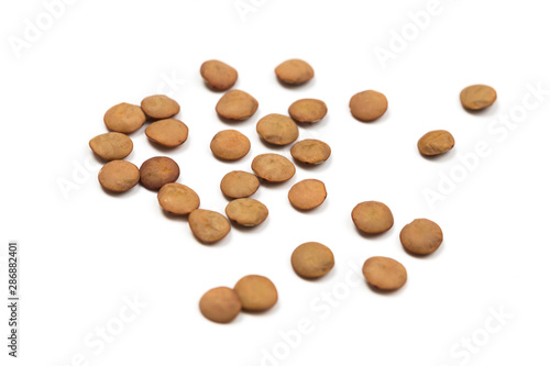 Isolated stack of uncooked lentils on white background from above.