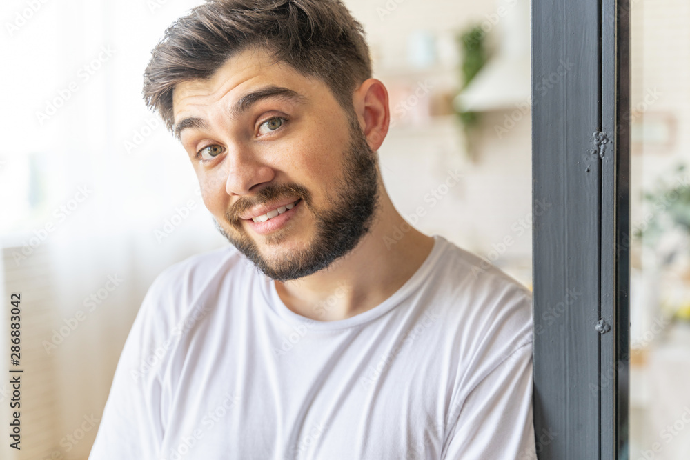 Cheerful bearded guy is posing at home
