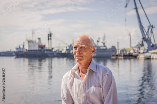 Portrait of an elderly man on the background of the bay