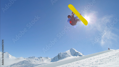 Photos Young pro snowboarder jumping over the sun in half pipe snow park