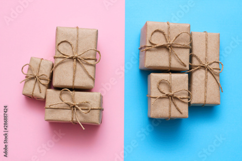 Gender determination day concept. Set of gift boxes. Pink and blue backgrounds. Girl or boy. Parcels wrapped in craft paper. 