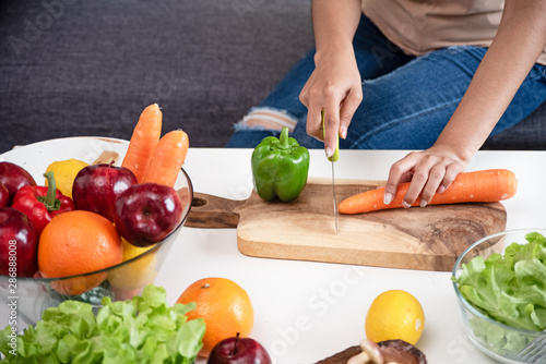 Human hand cutting carrot on wooden tray,Fresh vegetable was preparing for salad meal by beauty woman,healthy food,good for life