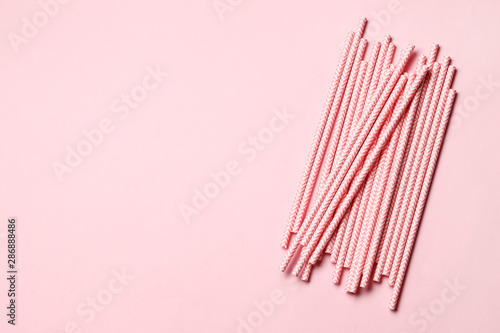 Pink paper straws on a pink background with place for text.