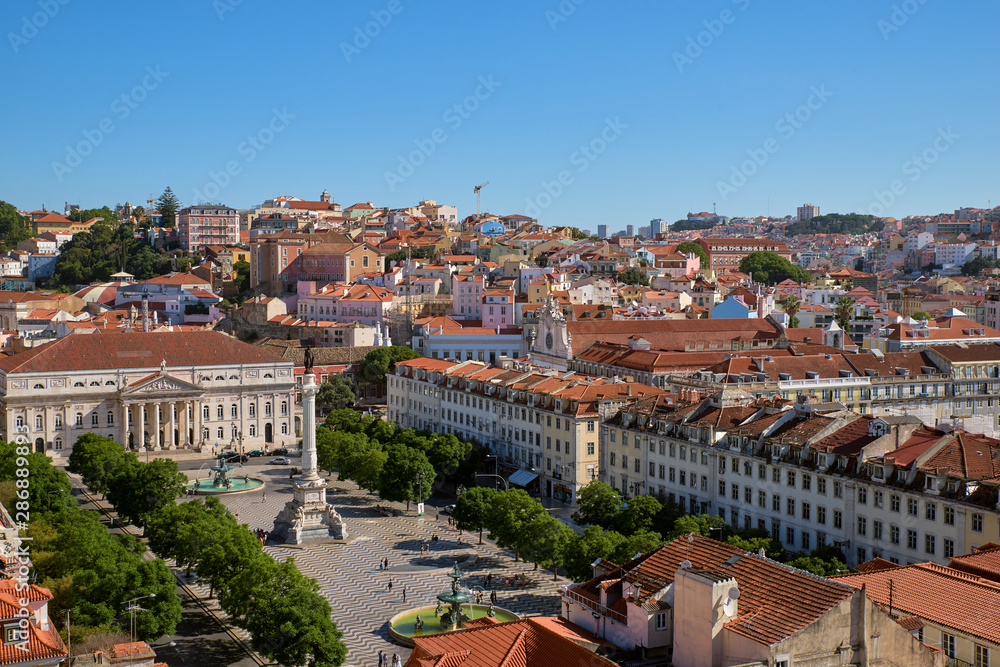 Panoramic aerial view over Rossio square, Pedro IV square, with Column of Pedro IV, National Theater, fountains and historical buildings, surrounding square, on hot summer day. Lisbon, Portugal.